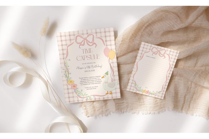 May include: Two pink and white gingham patterned cards with a floral design. The larger card has a pink bow and the text "Time Capsule To Celebrate [Name]'s 1st Birthday!" The smaller card has a blank space for writing.
