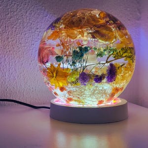 Lampada in resina epossidica con fiori secchi e base in cemento