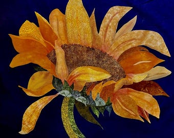 Könnte beinhalten: Detaillierte Nahaufnahme einer Sonnenblume mit leuchtend gelben und orangefarbenen Blütenblättern, einem dunkelbraunen Zentrum und grünen Blättern. Die Sonnenblume ist vor einem tiefblauen Hintergrund platziert, was einen auffälligen Kontrast erzeugt.