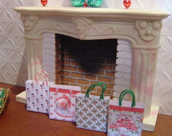 May include: Four miniature gift bags with different festive designs. The bags are in front of a white fireplace with a brick interior.