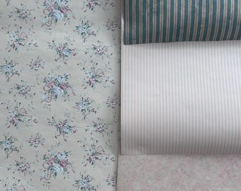 May include: Three samples of wallpaper, one with a floral pattern, one with pink and white stripes, and one with blue and white stripes.