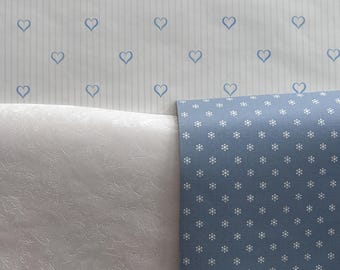May include: Two pieces of wallpaper, one with a white background and blue hearts, the other with a blue background and white polka dots.
