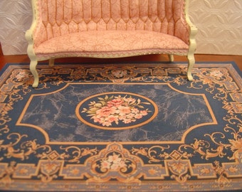 May include: A blue and cream patterned rug with a floral design in the center. The rug has a decorative border with intricate details.