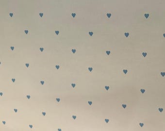 May include: A white background with a repeating pattern of small blue hearts.