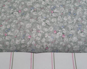 May include: Two rolls of wallpaper. The top roll features a green background with a white floral pattern. The bottom roll features a white background with vertical stripes of pink and green.