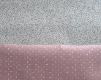 May include: Two fabric swatches with different patterns. The top swatch is white with a small blue and pink floral pattern. The bottom swatch is pink with a small white dot pattern.