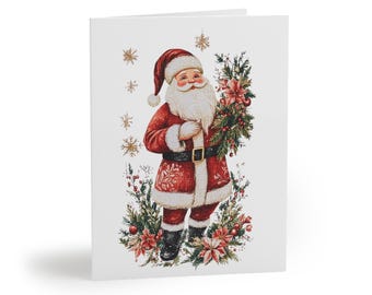 Può includere: Un biglietto di Natale con un'illustrazione ad acquerello di Babbo Natale. Indossa un abito rosso, barba e cappello bianchi, con in mano una composizione floreale. Fiocchi di neve dorati e accenti floreali lo circondano su sfondo bianco.