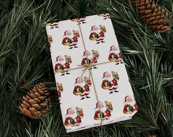 Puede incluir: Un regalo envuelto con un patrón repetido de figuras de Papá Noel sobre papel blanco. El regalo está atado con hilo y descansa sobre un lecho de agujas de pino verdes y piñas, creando una escena festiva navideña.