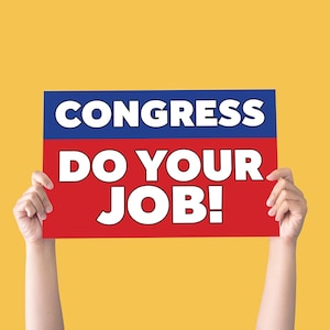 May include: A rectangular sign held up by two hands, featuring the words "CONGRESS" in white on a blue background, and "DO YOUR JOB!" in white on a red background. The background is a solid yellow.