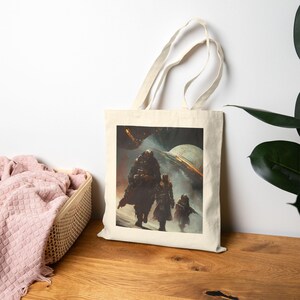 May include: A beige tote bag featuring a science fiction illustration of three figures walking towards a futuristic spacecraft. The artwork is rendered in shades of brown, gray, and white, creating a dramatic, atmospheric scene.