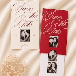 May include: Two rectangular Save the Date cards, one cream and one red, featuring elegant script text and a pull-out mechanism. Each card displays a black and white photo strip of a couple, with the date 23.07.2027 printed on the cream card.