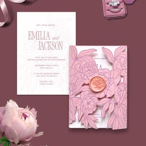 Könnte beinhalten: Eine Hochzeitseinladungssuite mit einer lasergeschnittenen rosa Einladung mit floralen Details und einem Wachssiegel. Die Einladung enthält die Namen "Emilia und Jackson" und Veranstaltungsdetails. Eine Ringbox und ein Ring sind ebenfalls sichtbar.