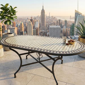 Könnte beinhalten: Ein ovaler Gartentisch mit einer Mosaik-Tischplatte und einem schwarzen Metallrahmen. Der Tisch ist von Topfpflanzen umgeben und hat eine Stadtlandschaft im Hintergrund. Der Tisch ist etwa 152 cm lang.