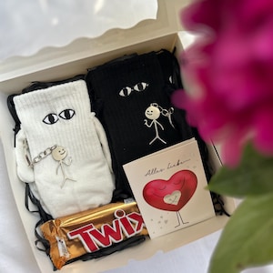 Un regalo para una pareja: calcetines, llavero, dulces, tarjeta, envoltorio de regalo.