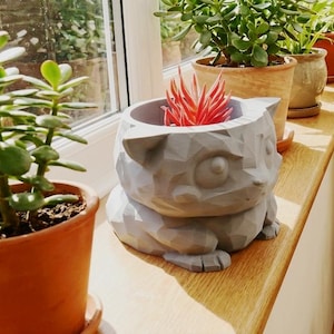 Puede incluir: Un juego de tres tazas de cerámica con un acabado mate moteado. Las tazas son de color crema, gris claro y gris oscuro. Cada taza tiene un diseño simple y minimalista.