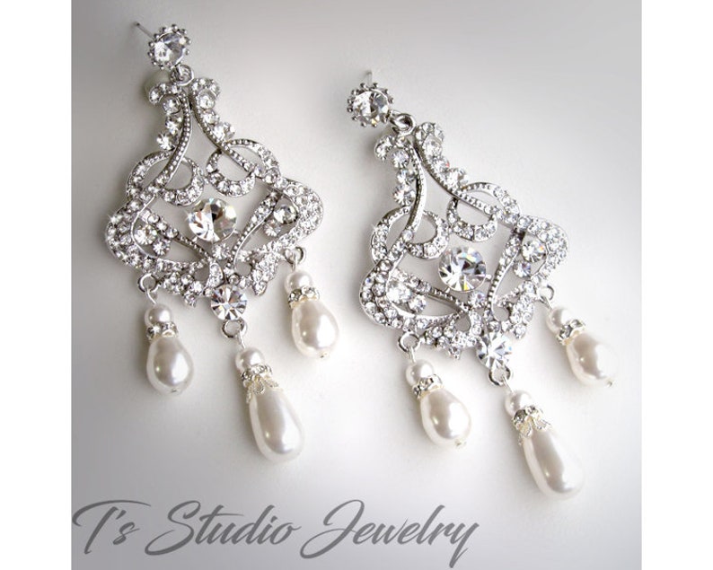 May include: Silver chandelier earrings with crystal accents and pearl drops.