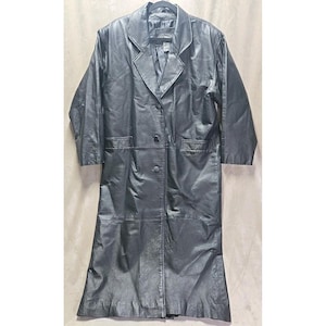 May include: A long, black leather coat with a notched collar, two rows of buttons, and two front pockets. The coat is hanging on a black hanger against a neutral background. The coat appears to be knee-length.