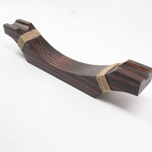 May include: A dark stained wooden handle with a curved design. The handle is wrapped with twine at both ends. The wood grain is visible, and the handle is set against a white background.