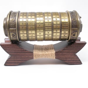 May include: A brass-colored cipher cylinder with rotating lettered rings, resting on a dark wooden stand. The stand is held together with twine. The cylinder has an antique aesthetic, with engraved details and a series of letters.