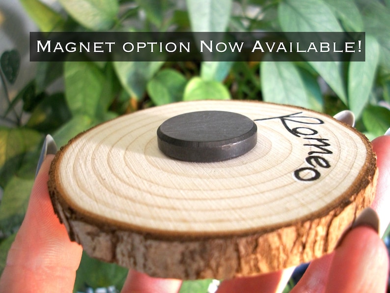 May include: A wooden round slice with the word "Romeo" written on it. A black round magnet is attached to the back of the slice.