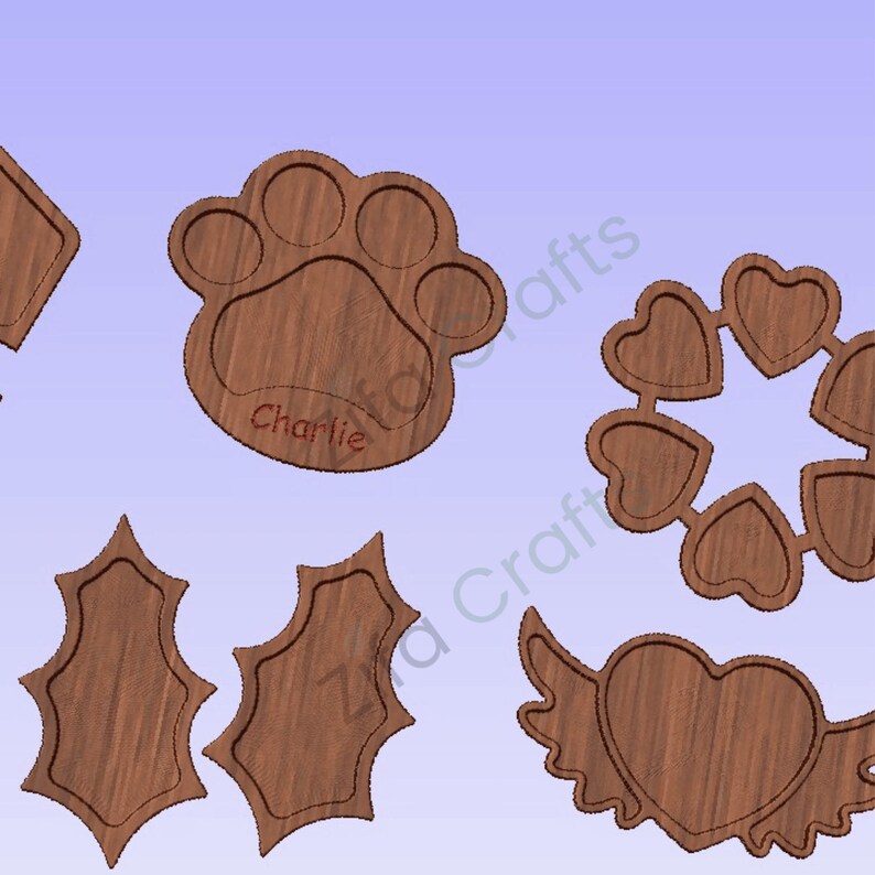 May include: A collection of brown wooden craft shapes featuring a paw print with the name Charlie engraved, a circular arrangement of six hearts, two holly leaf shapes, and a heart with wings. Each piece has a recessed center and wood grain.
