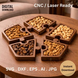 Puede incluir: Cinco bandejas de madera para servir en forma de rompecabezas llenas de almendras, anacardos, nueces, pasas y otros frutos secos. Las bandejas están dispuestas sobre una mesa redonda de madera. El texto "CNC / Laser Ready" está incluido.