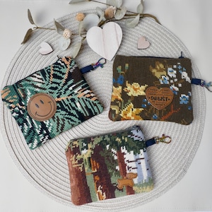 May include: A white ceramic mug with a black handle and the text "But First, Coffee" in a black, handwritten-style font. The mug is on a white surface.