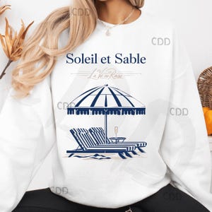 Soleil et Sable png con sedie a sdraio a righe, ombrellone da spiaggia, bicchiere di champagne e testo in francese, elegante design estivo parigino con arte costiera