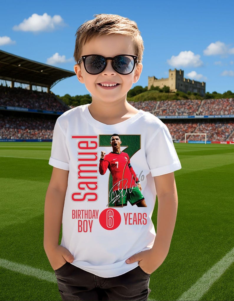 May include: A white t-shirt with a soccer theme. The shirt features a photo of a soccer player in a red jersey, with the name "Samuel", "Birthday Boy", and "6 Years" printed on it. The boy is wearing sunglasses.