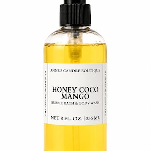 May include: A clear plastic bottle filled with yellow liquid bubble bath and body wash. It features a black pump dispenser and a white label reading ANNE'S CANDLE BOUTIQUE, HONEY COCO MANGO, BUBBLE BATH & BODY WASH, NET 8 FL. OZ. | 236 ML.