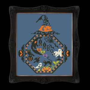Puede incluir: Obra de arte de punto de cruz en un marco negro con un diseño de Halloween. El diseño incluye un sombrero de bruja, calabazas, fantasmas, murciélagos y la palabra "BOO". La obra de arte está sobre un fondo azul.