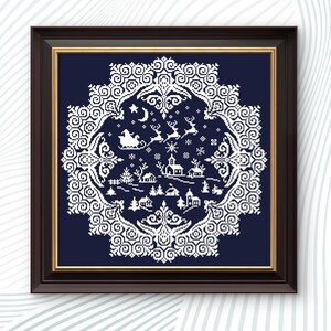 May include: Framed cross-stitch art featuring a winter village scene with Santa's sleigh, reindeer, and snowflakes. The design is white on a navy blue background, framed in a dark brown frame with a gold inner border. The artwork has a circular, ornate border.