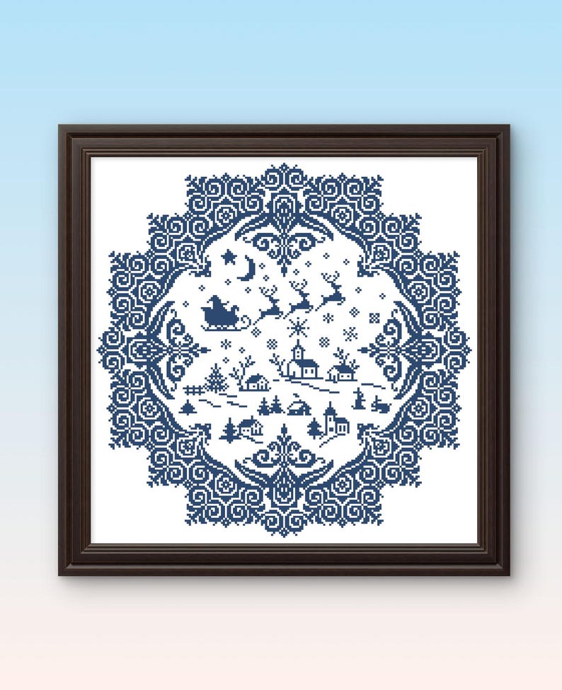 May include: Framed cross-stitch artwork featuring a winter village scene in shades of blue and white. The design includes Santa in his sleigh, reindeer, houses, trees, and snowflakes, surrounded by a decorative border. The frame is dark brown.