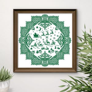 May include: A framed cross-stitch depicting a winter village scene in green thread on a white background. The design features a circular border with snowflakes, a sleigh, reindeer, houses, and trees. The frame is a dark brown color.