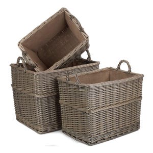 May include: Three rectangular woven wicker baskets in varying sizes. The baskets are a natural gray color and have a burlap lining. Each basket has two curved handles for easy carrying. The baskets are stacked, with one partially inside another.