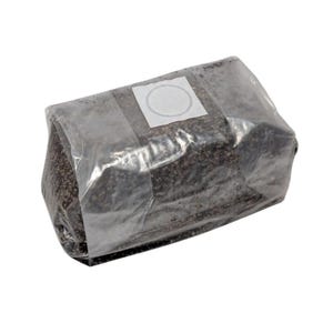 Puede incluir: Una bolsa de plástico transparente llena de una sustancia granular de color marrón oscuro. Una etiqueta blanca con un círculo está en la bolsa.