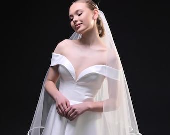 Velo de novia de largo capilla con ribete de satén y velo corto de tul.