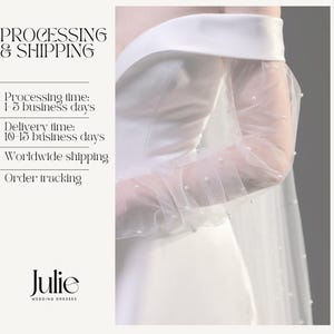 May include: A white wedding dress with an off-the-shoulder neckline and sheer sleeves adorned with small pearls. The dress features a flowing design, with the text "Julie WEDDING DRESSES" at the bottom.