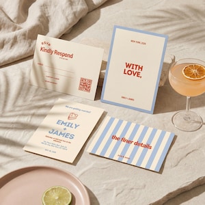 May include: A collection of wedding stationery, including RSVP cards, invitation cards, and detail cards. The cards feature text in red and blue, with a light beige background. A cocktail with an orange slice garnish is visible.