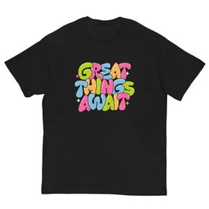 Grandes coisas aguardam, camiseta motivacional, vibrações positivas, estética Y2K, design colorido, citação inspiradora, letras em formato de bolha, camiseta fofa