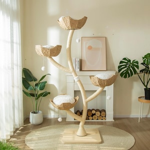 May include: A multi-level cat tree with four woven baskets and soft, white cushions. The tree has a natural, tree-like design with a sisal-wrapped trunk and branches. Includes hanging pom-poms for play. The base is a light-colored wood.