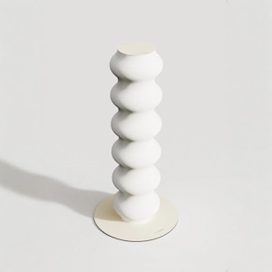 Peut inclure: Un objet sculptural blanc orienté verticalement, composé d'une série de six segments arrondis et nervurés empilés. La structure repose sur une base circulaire plate et est surmontée d'un disque assorti, créant un aspect uniforme et texturé.