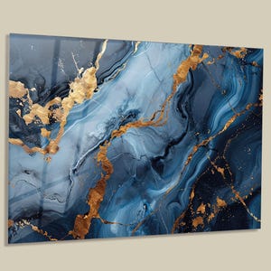 May include: A rectangular wall art piece featuring a fluid abstract design with swirling shades of deep navy blue, light blue, and white, accented by prominent, textured metallic gold veins that traverse the surface in a marble-like pattern.
