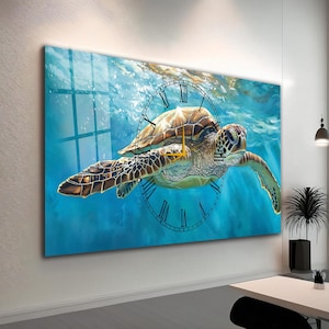 May include: A large wall clock featuring a sea turtle swimming underwater. The clock face is a transparent overlay with black Roman numerals. The turtle has a brown and green shell, and the background is a vibrant blue.