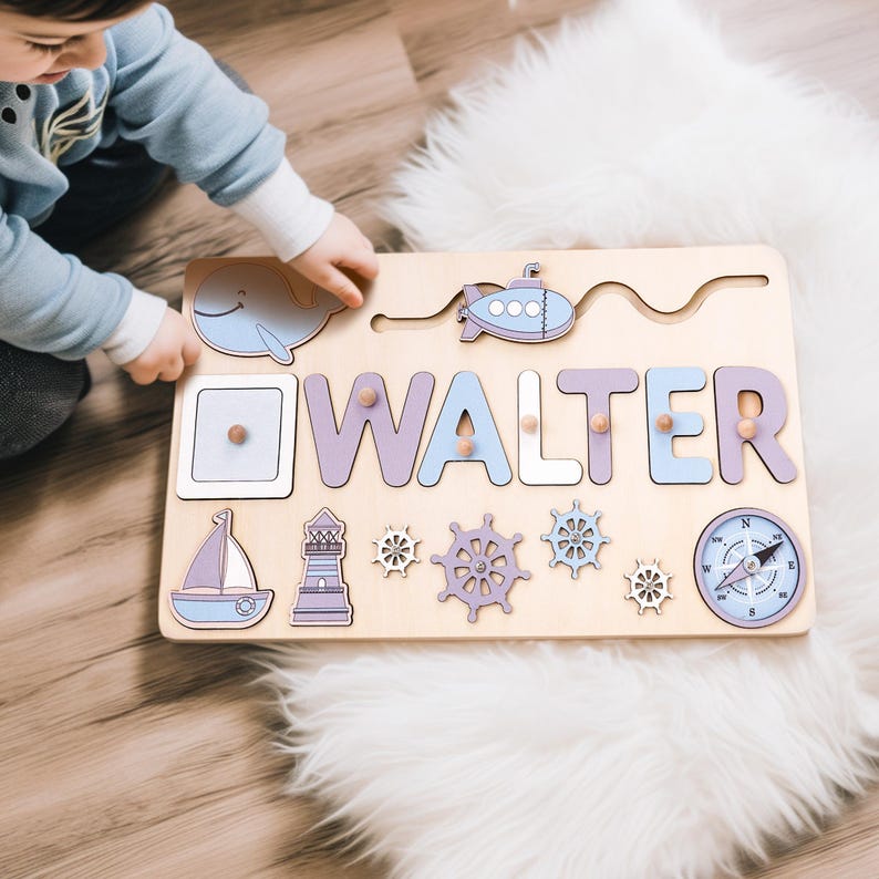 K&ouml;nnte beinhalten: Holz-Namenspuzzle mit dem Namen "WALTER" in lila und blauen Buchstaben. Das Puzzle enth&auml;lt nautische Formen wie einen Wal, ein Segelboot, einen Leuchtturm und einen Kompass. Das Puzzle befindet sich auf einer hellen Holzbasis.