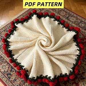 Könnte beinhalten: Cremefarbene Häkeldecke mit Spiralmuster. Die Decke ist mit einem dunkelgrünen Rand und roten Rosenakzenten versehen. Der Text "PDF PATTERN" wird in einem gelben Rechteck angezeigt.