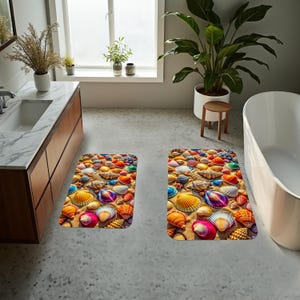 Può includere: Due tappeti da bagno rettangolari con un design a conchiglie. I tappeti presentano una varietà di conchiglie colorate nelle tonalità dell'arancione, giallo, rosa, blu e viola, disposte su uno sfondo sabbioso. I tappeti sono progettati per un bagno.