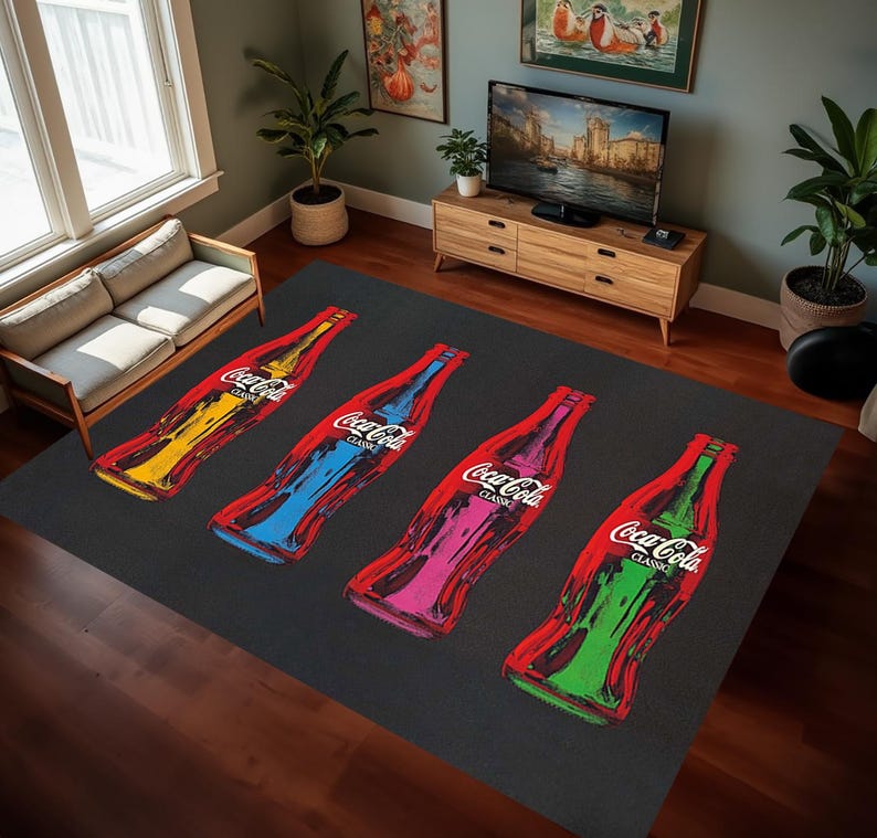Puede incluir: Una alfombra negra con cuatro botellas de Coca-Cola impresas en ella. Las botellas son de diferentes colores: amarillo, azul, rosa y verde. Las botellas est&aacute;n dispuestas horizontalmente a trav&eacute;s de la alfombra.