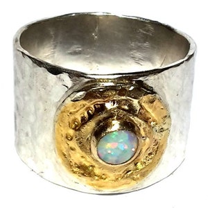 May include: A silver ring with a hammered texture and a gold accent featuring an opal gemstone.