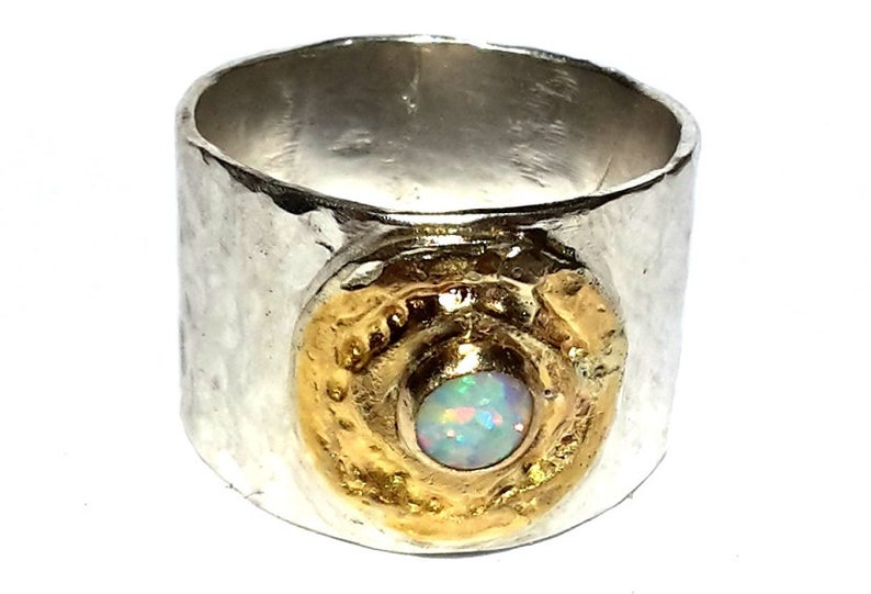 May include: A silver ring with a hammered texture and a gold accent featuring an opal gemstone.